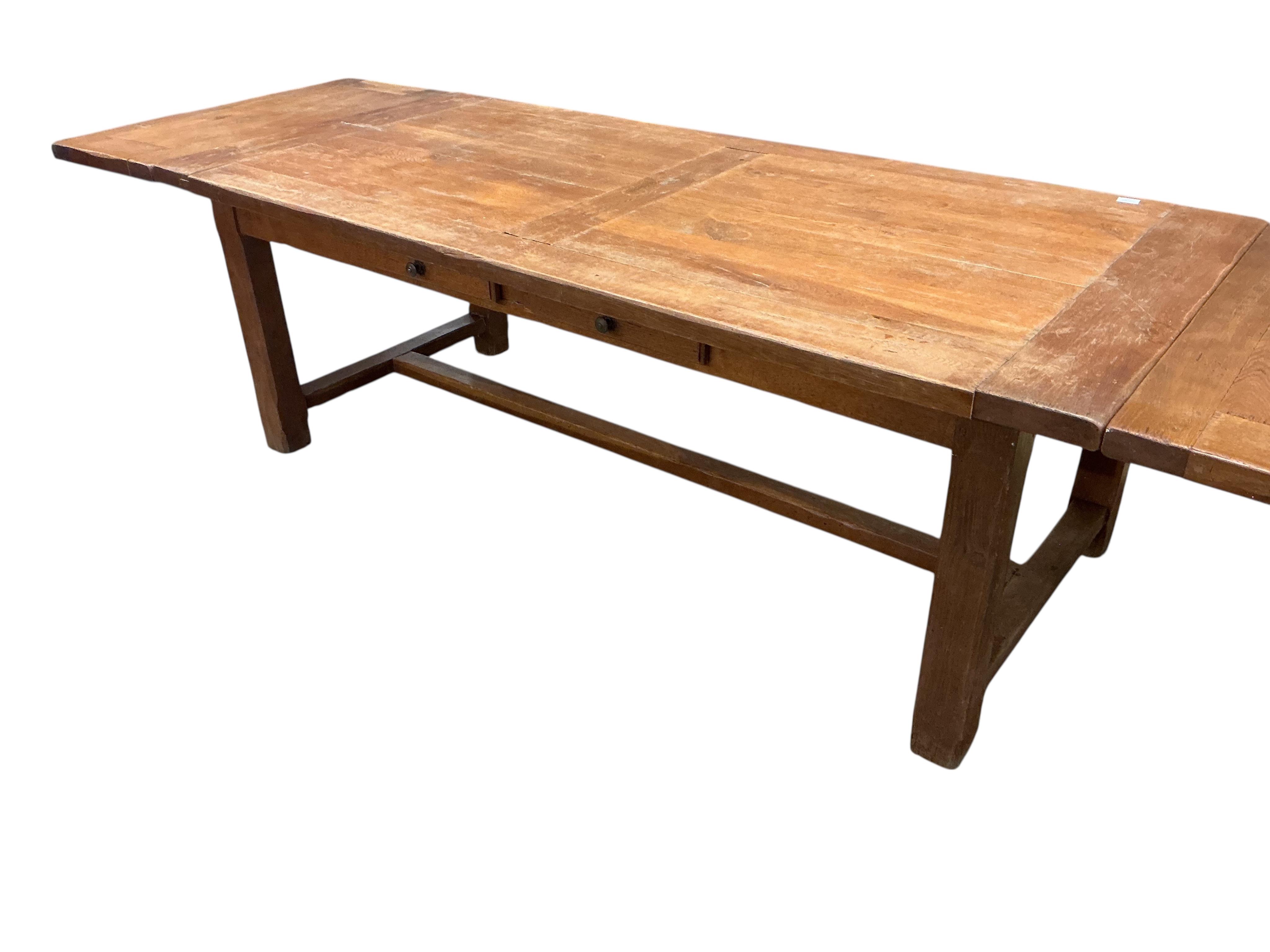 A Contemporary rectangular oak extending refectory dining table, width 320cm extended, two detachable end leaves, depth 100cm, height 76cm together with eight matching ladderback dining chairs, two with arms